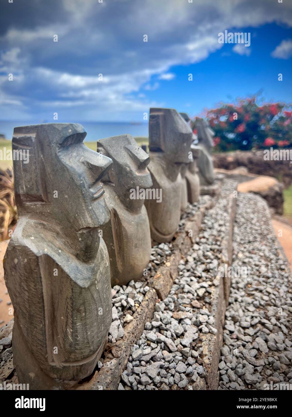 Rangée de statues moai miniatures exposées à l'extérieur sur l'île de Pâques, au Chili. Ces répliques capturent l'art ancien de Rapa Nui sur fond de ciel - Image de stock capturée avec un smartphone