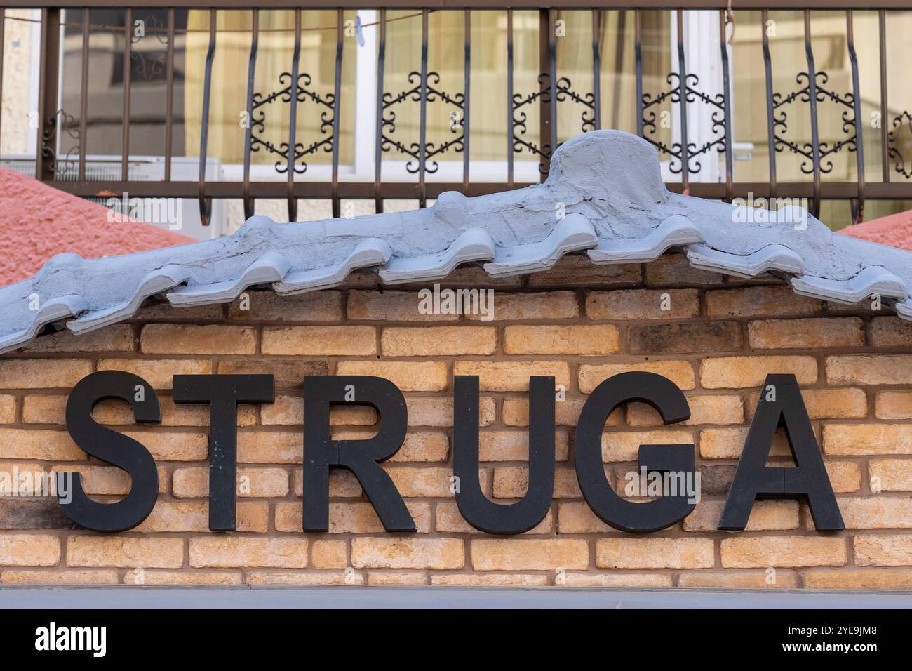 Signalisation Struga : lettres noires sur le mur de briques jaunes Banque D'Images