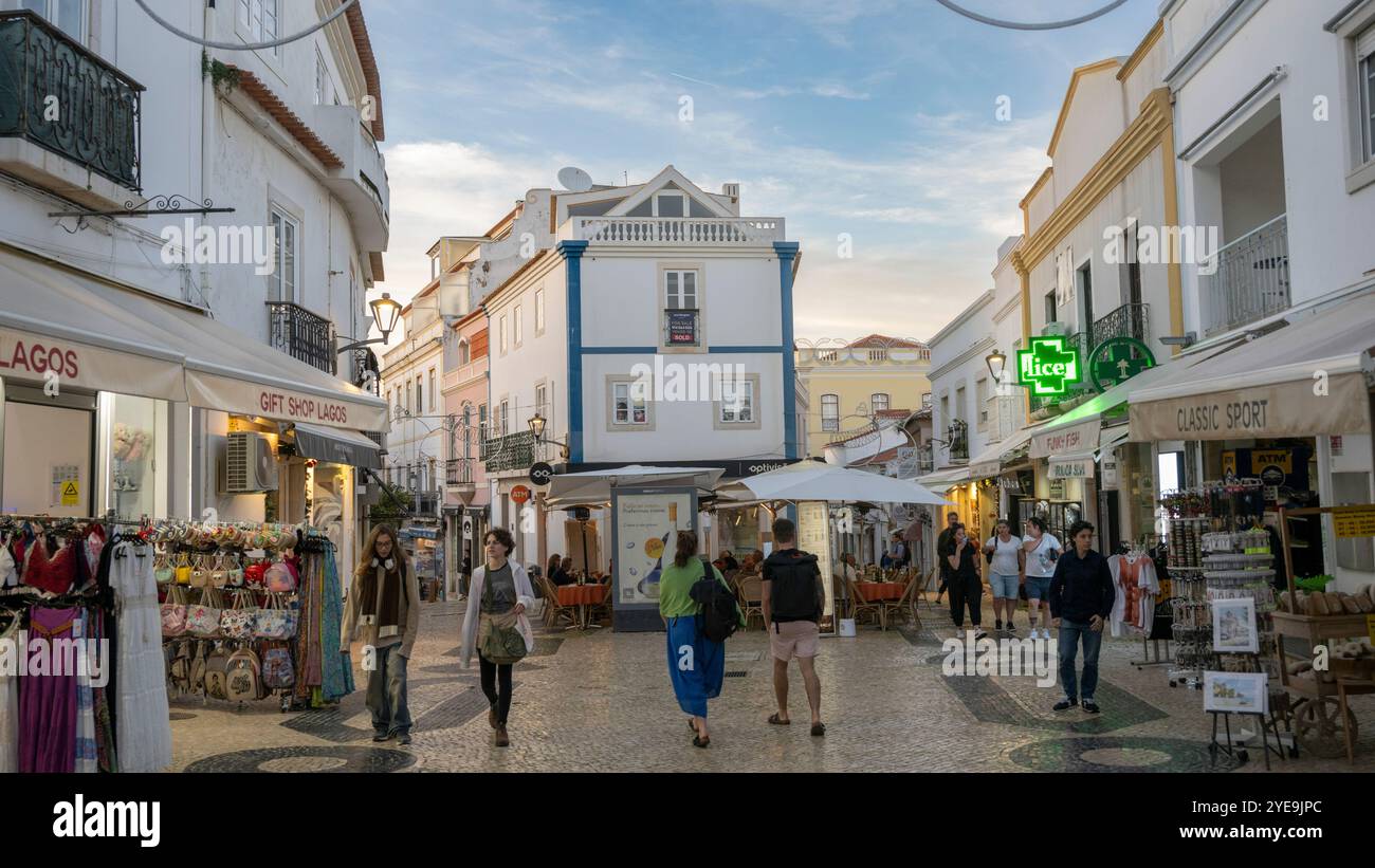 Scène de rue au crépuscule avec des piétons et des magasins dans la ville de Lagos, Portugal. Lagos est une ville de la région de l'Algarve au sud du Portugal. C’est kno... Banque D'Images