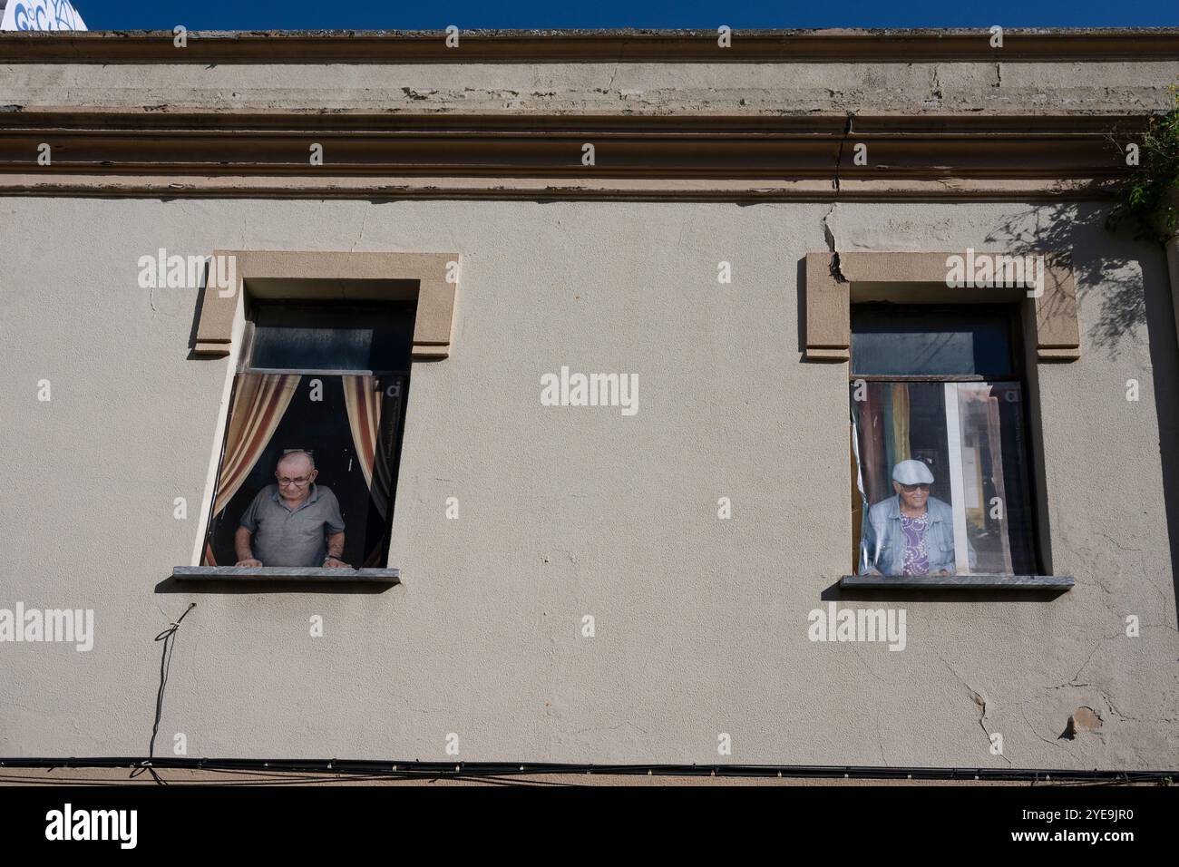 Hommes âgés regardant par les fenêtres de leurs maisons dans la ville de Sines dans la région de l'Alentejo au Portugal ; Sines, Setubal, Portugal Banque D'Images