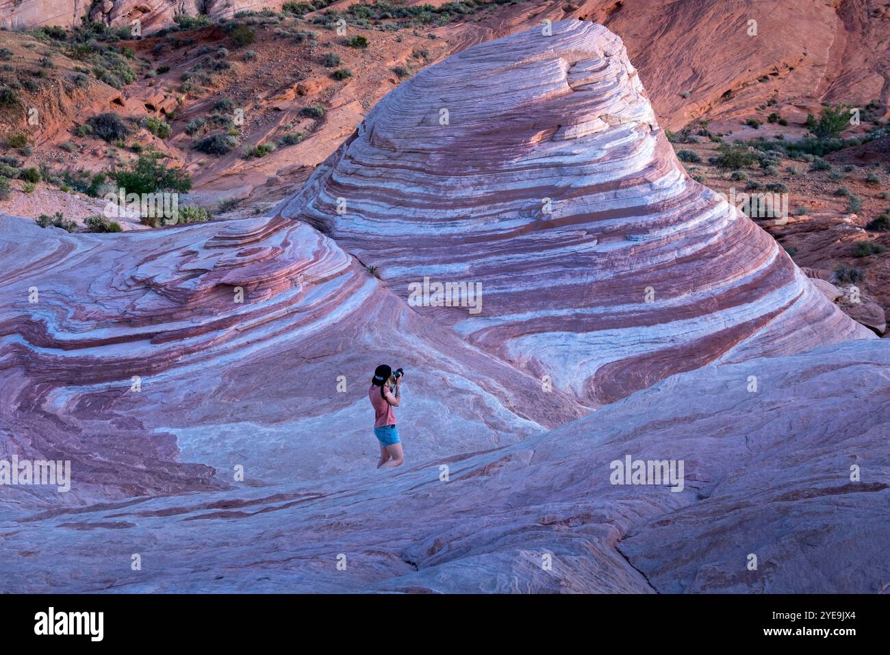 Une jeune femme photographie la célèbre formation rocheuse de Fire Wave, Valley of Fire State Park, Nevada, États-Unis d'Amérique, Amérique du Nord Banque D'Images