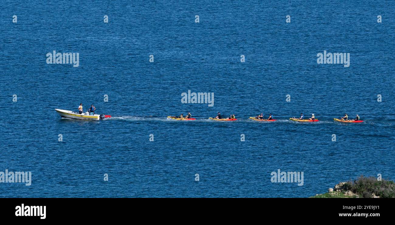 Touristes dans des bateaux à moteur dans une rangée se déplaçant le long de la côte de la Ponta da Piedade sur la côte atlantique du Portugal ; Lagos, Faro, Portugal Banque D'Images