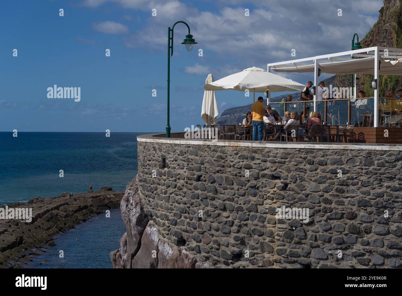 Les gens apprécient une chaude journée ensoleillée sur un patio le long de la côte de Madère, Portugal ; Ponta do sol, Madère, Portugal Banque D'Images