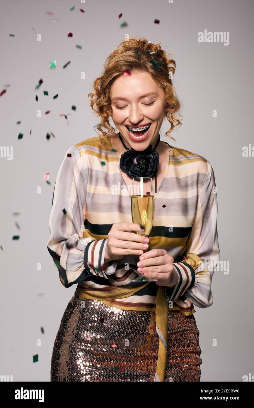 Une jeune femme posant joyeusement, souriante au milieu de la célébration festive autour d'elle. Banque D'Images