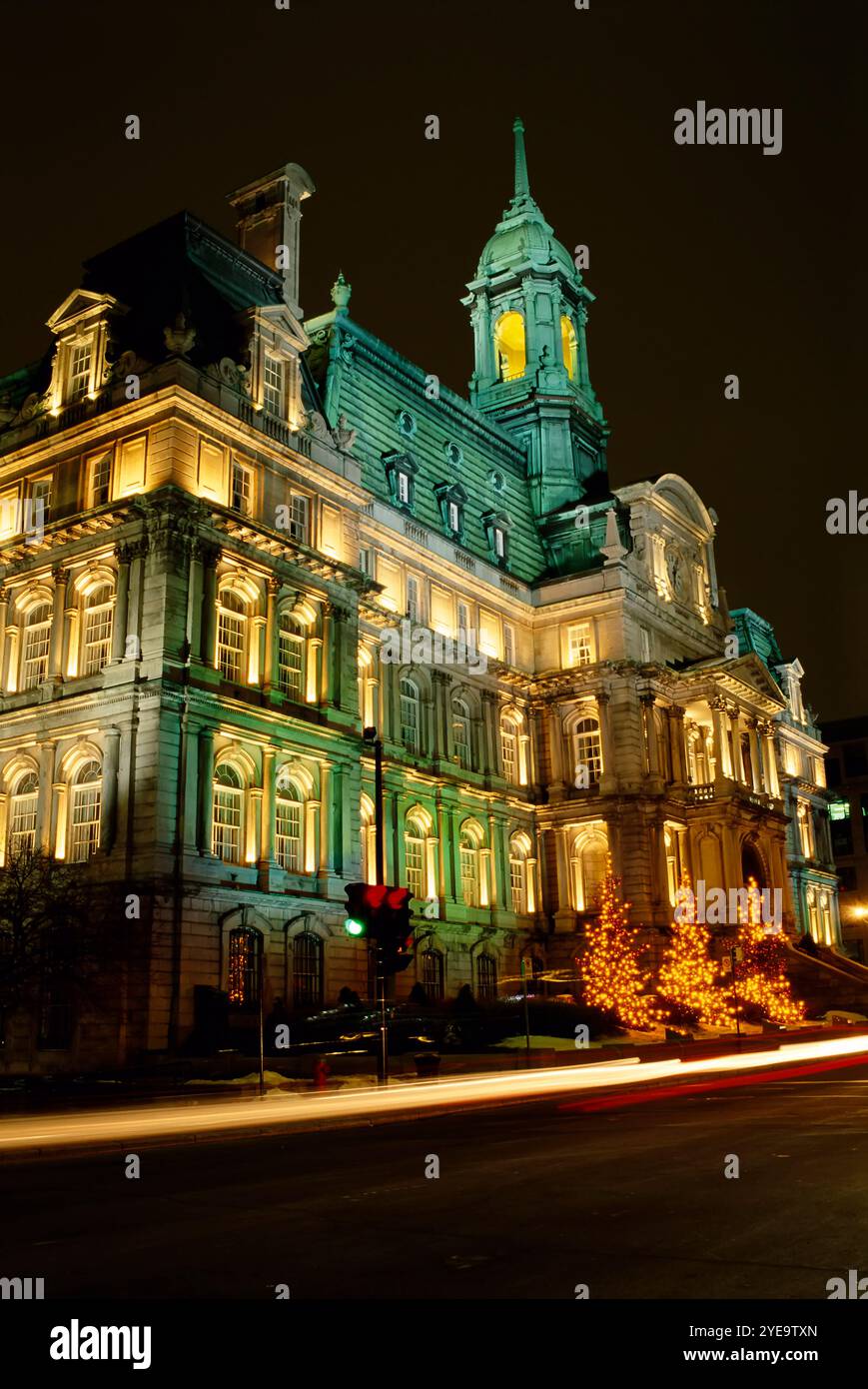 Hôtel de ville de Montréal illuminé à Noël dans le Vieux-Montréal, avec des sentiers lumineux dans la rue ; Montréal, Québec, Canada Banque D'Images