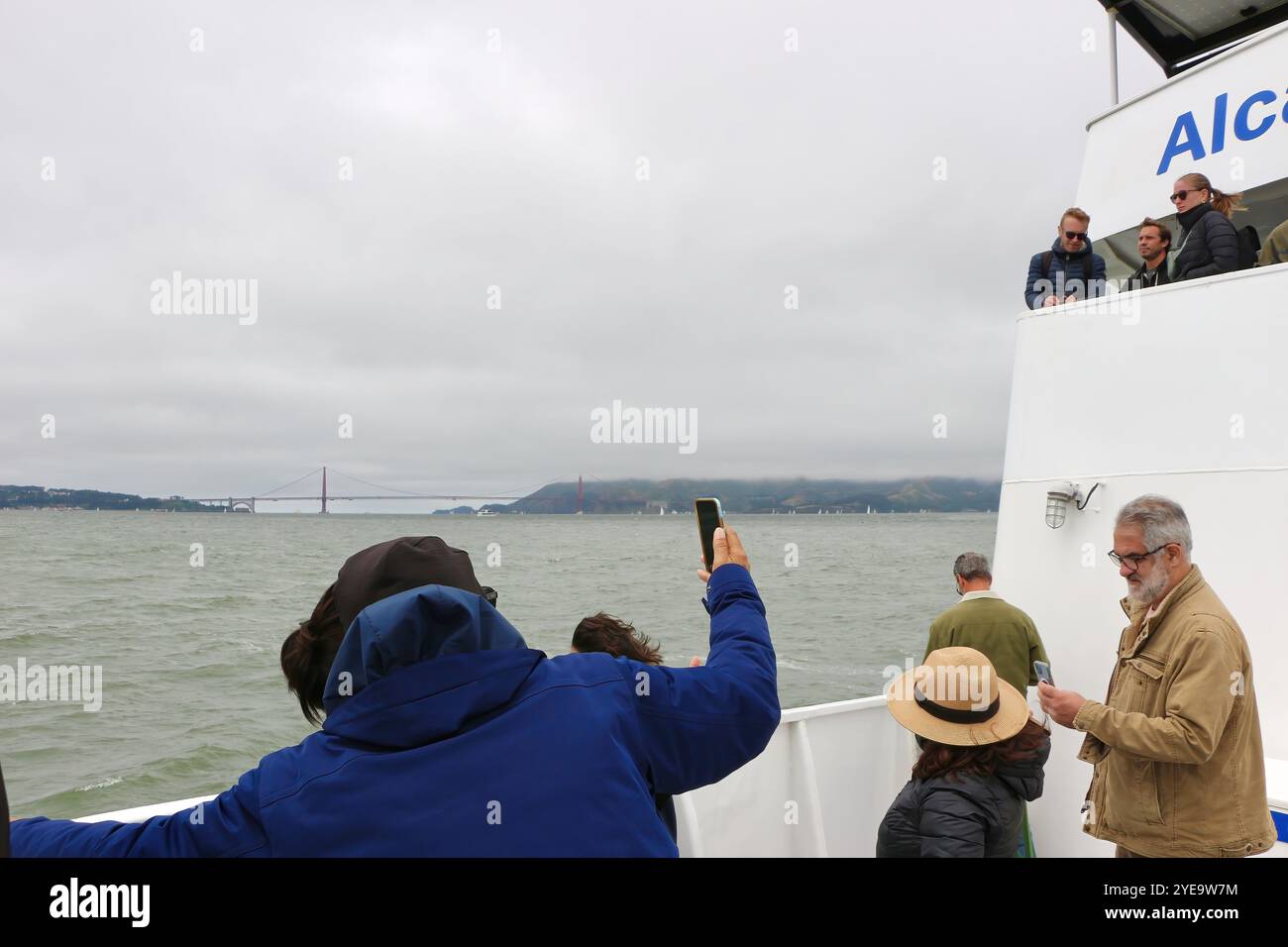Touristes utilisant des téléphones portables prendre des photos quittant Alcatraz à bord d'un Alcatraz City Cruises par Hornblower Tourist Boat San Francisco California USA Banque D'Images
