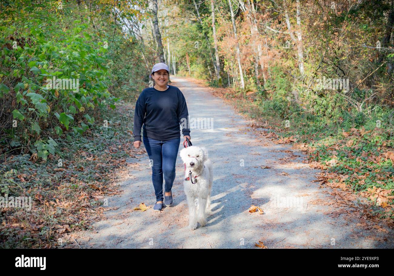 Femme promène son chien sur le sentier de la vallée de Cowichan sur l'île de Vancouver, C.-B., Canada ; Ladysmith, Colombie-Britannique, Canada Banque D'Images