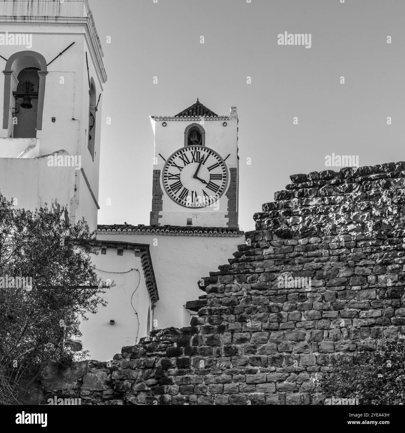 Vieille tour de l'horloge sur le clocher de l'église dans la ville mauresque de Tavira le long de la côte de l'Algarve chevauchant la rivière Gilão ; Tavira, Algarve, Portugal Banque D'Images