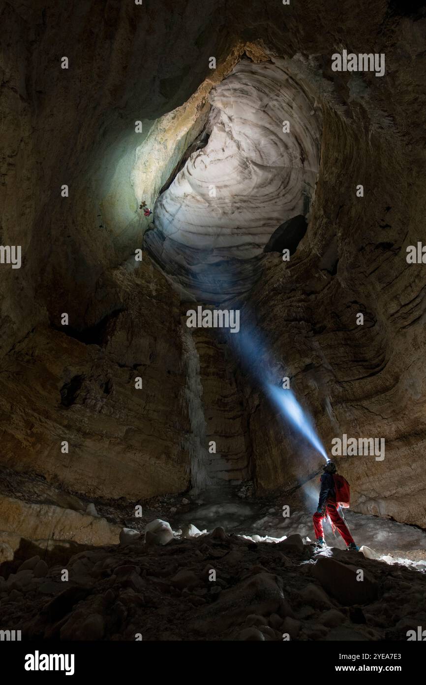 Des cavaliers en rappel explorant les formations de glace dans les grottes des Alpes européennes, menacées par le réchauffement climatique. Le beau, spectaculaire et un... Banque D'Images