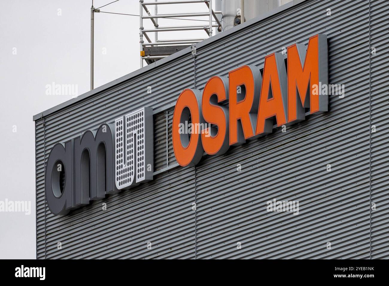 Unternehmen in Regensburg Detailansicht des logos der Osram Opto Semiconductors GmbH, Teil der Ams Osram AG, an der Metallfassade des Werks in Regensburg. DAS Firmenlogo Ams osram ist in großen, schwarzen und orangefarbenen Buchstaben angebracht und hebt sich kontrastreich vom grauen Hintergrund ab. Regensburg Burgweinting - Harting Bayern Deutschland *** entreprise à Ratisbonne vue détaillée du logo d'Osram Opto Semiconductors GmbH, qui fait partie de la société AMS Osram AG, sur la façade métallique de l'usine de Ratisbonne le logo de la société AMS OSRAM est affiché en grandes lettres noires et oranges et se distingue i. Banque D'Images