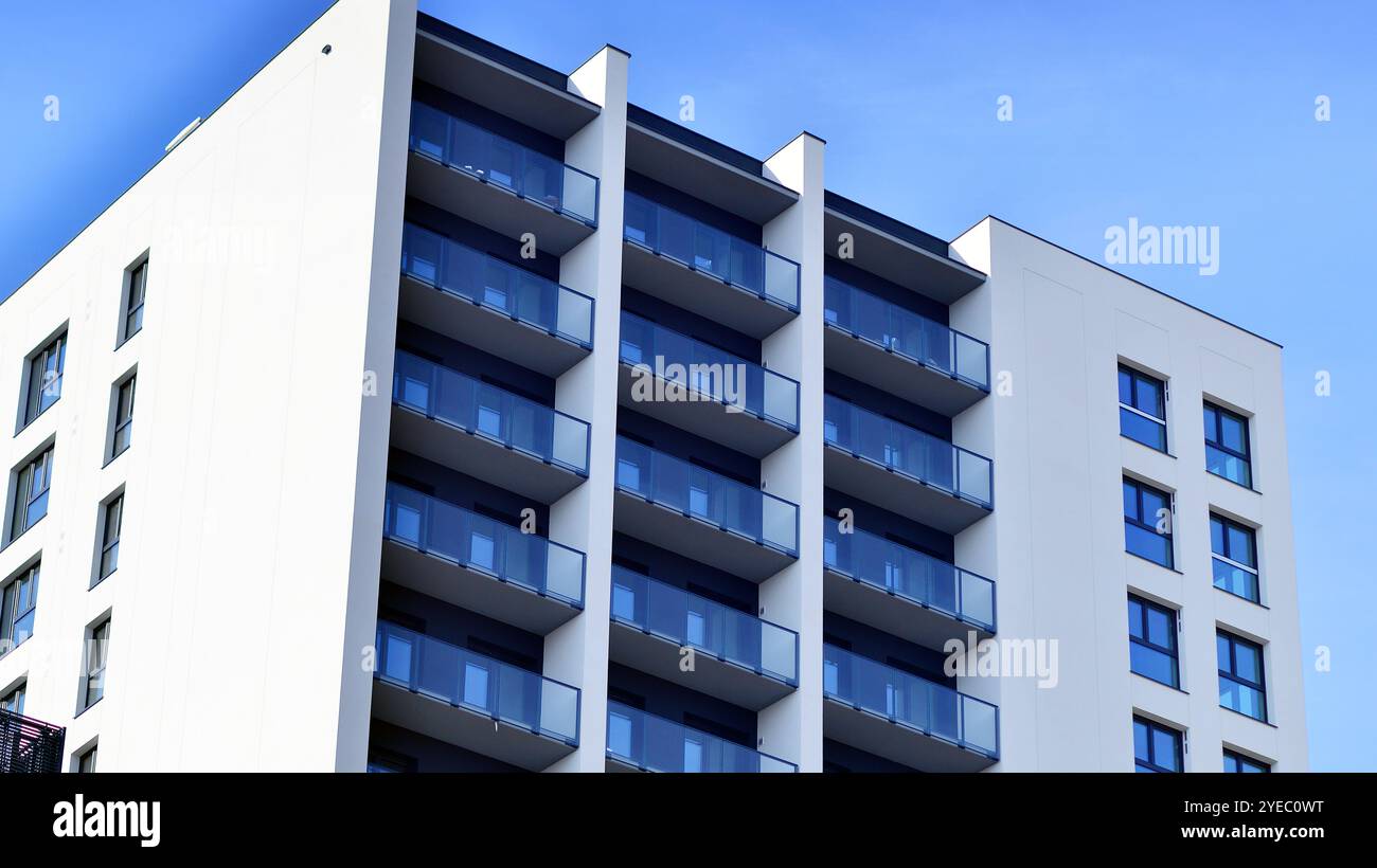 Immeuble moderne de grande hauteur blanc, debout contre un ciel bleu, illustrant une architecture urbaine innovante avec des designs élégants et angulaires. Banque D'Images