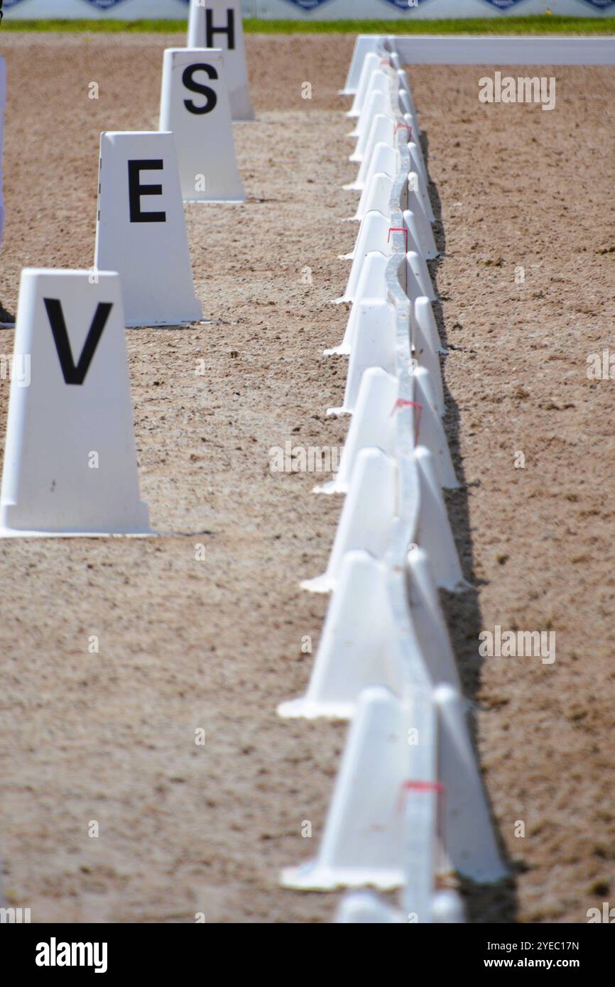 Gros plan sur la clôture blanche et les marqueurs de lettres dans le ring lors d'un concours de dressage de chevaux. Banque D'Images