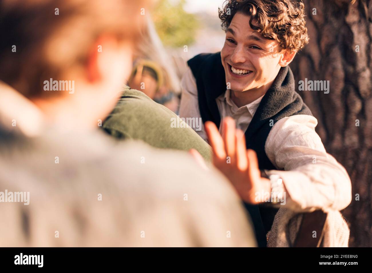 Heureux jeune homme appréciant avec des amis au dîner Banque D'Images