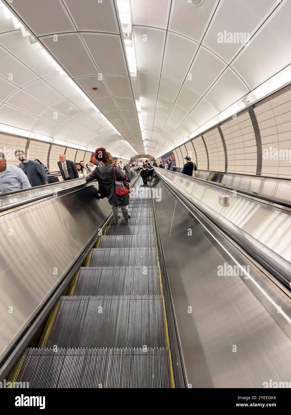 Regarder vers le bas les gens qui montent un escalier roulant à l'intérieur d'une station de métro de New york très fréquentée, avec des navetteurs à manhattan nyc usa - Image de stock capturée avec un smartphone