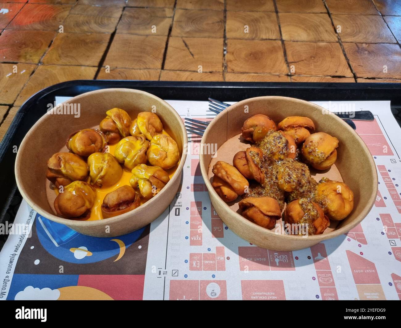 Deux types de pelmeni cuits au four : avec sauce miel-moutarde et avec sauce au fromage ; cuisine russe, nourriture traditionnelle Banque D'Images