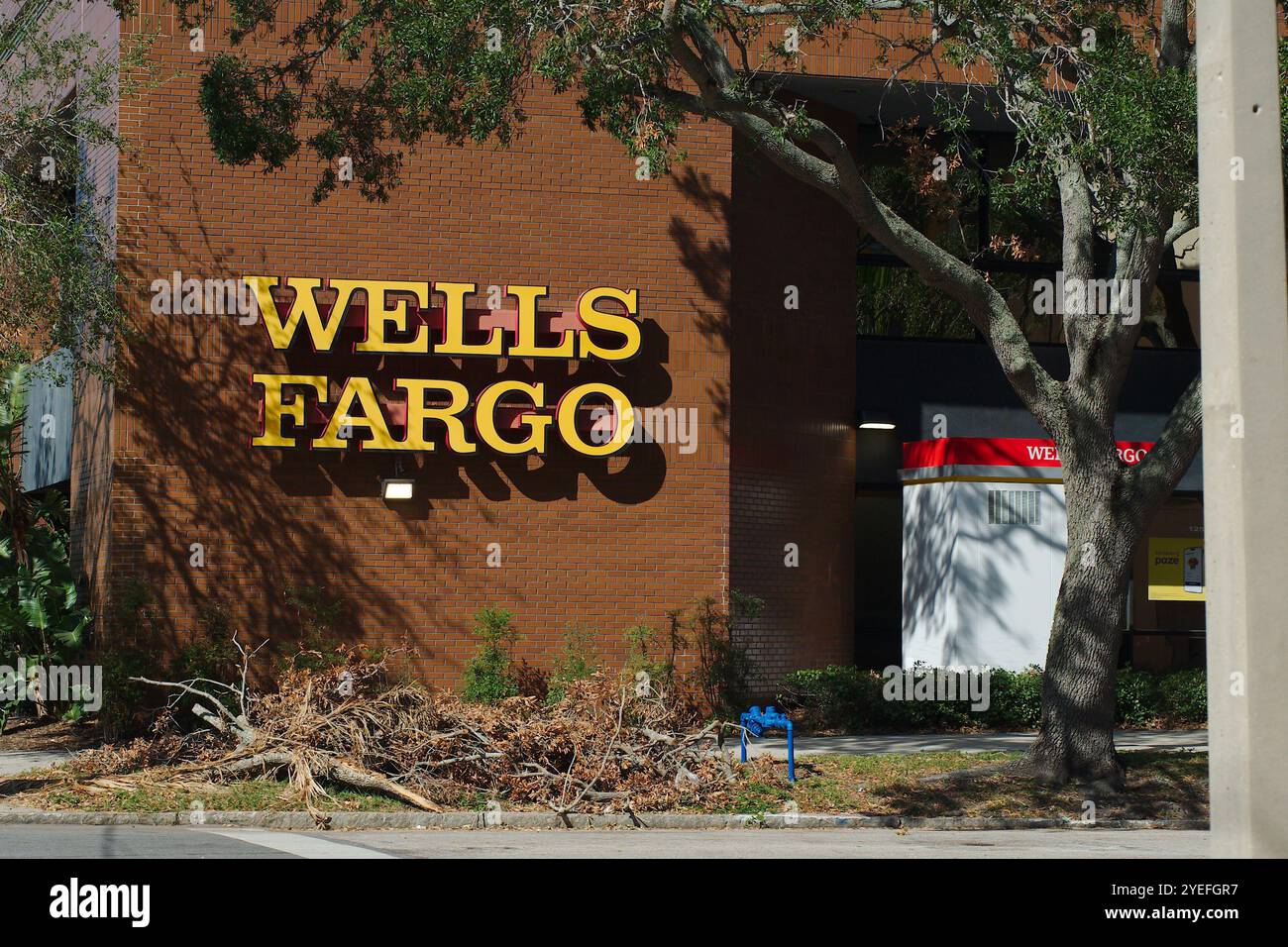 Puits Fargo Bank bâtiment de brique et distributeur automatique de billets à l'extérieur et arbre. Soleil tôt le matin. Usage éditorial seulement 29 octobre 2024, produit Petersburg Florida, USA Banque D'Images