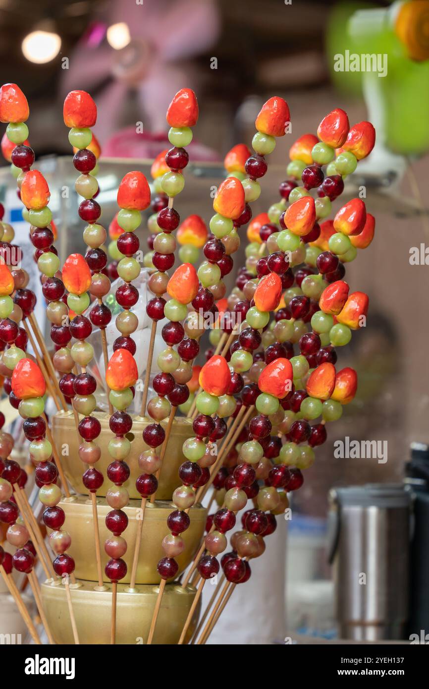 Brochettes de fruits avec enrobage de sucre vendues à un étal alimentaire. Il est également connu sous le nom de Tanghulu. Banque D'Images