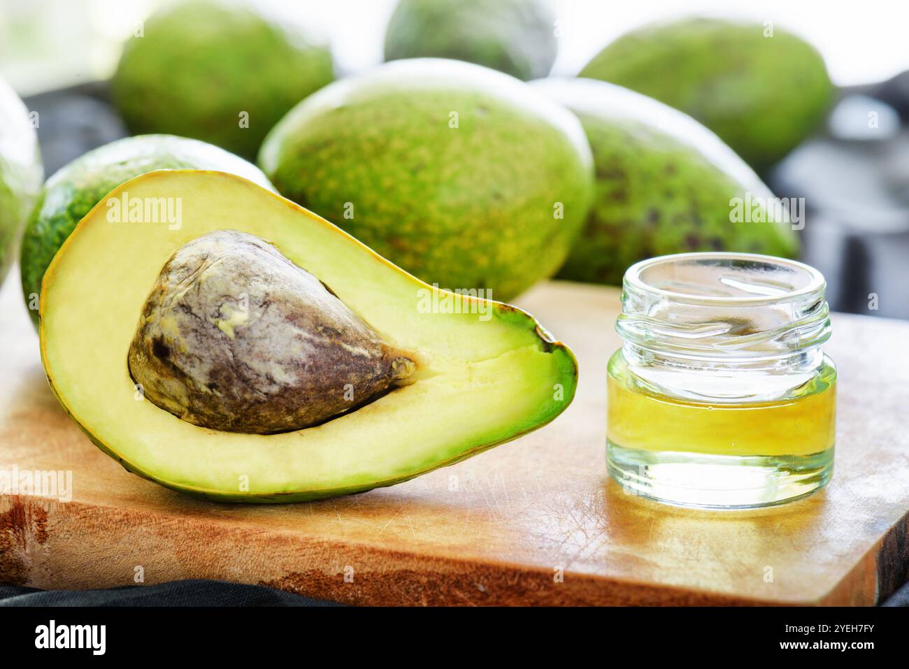 Avocat frais mûr et huile d'avocat naturelle sur planche de bois Banque D'Images