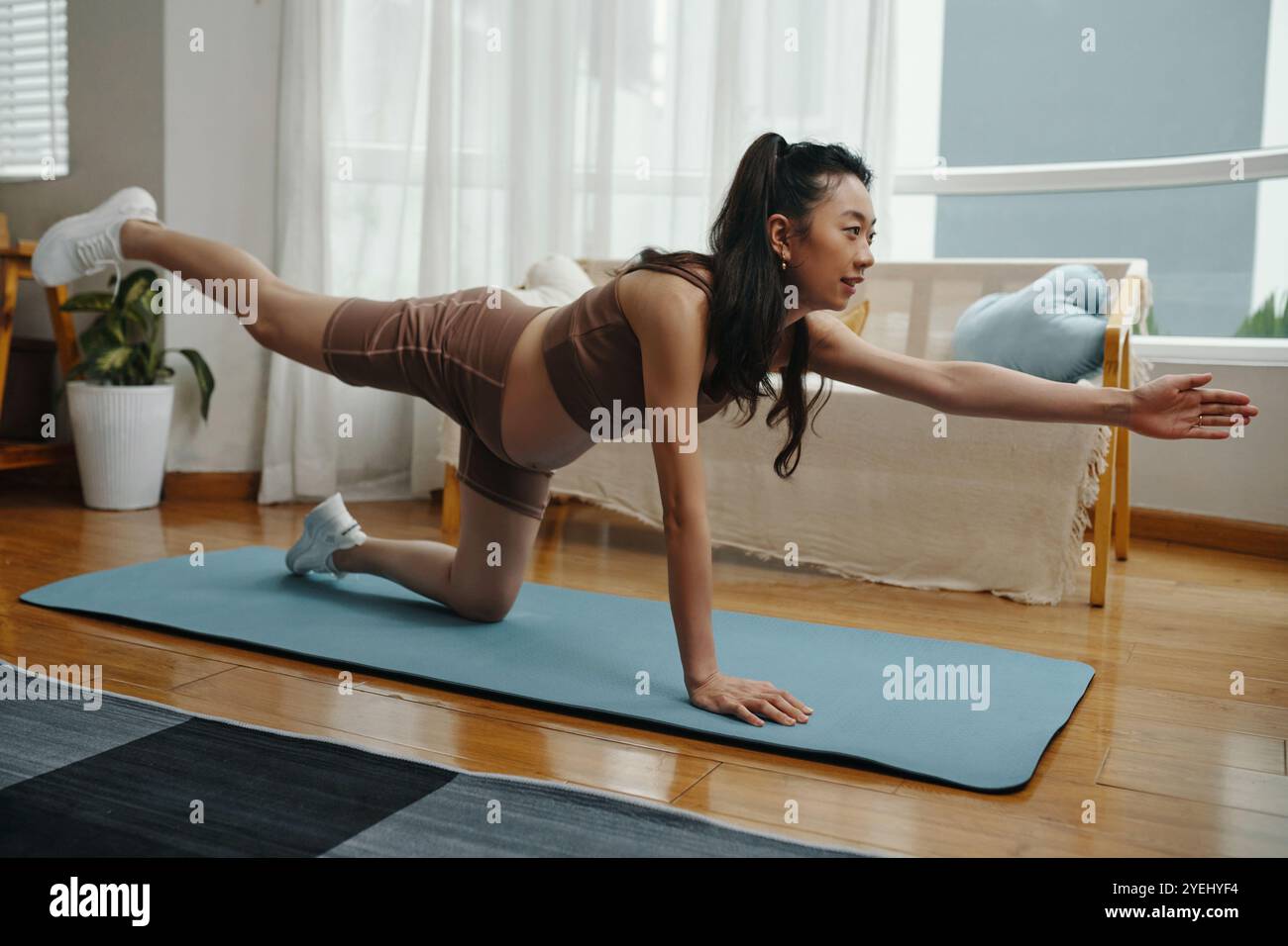 Femme enceinte pratiquant le yoga sur tapis bleu Banque D'Images