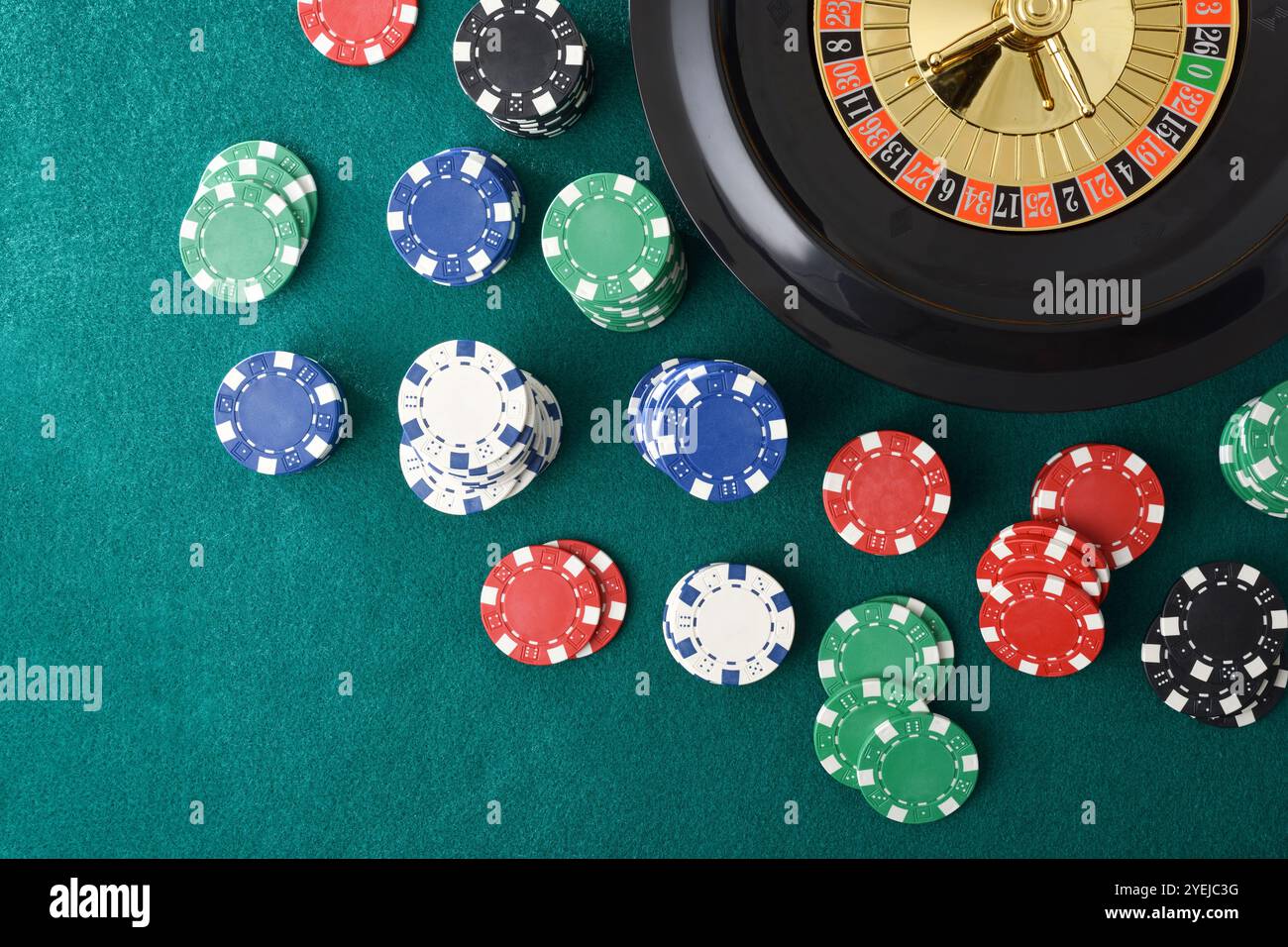 Roulette de casino isolé sur tapis de feutre vert avec des jetons colorés pour parier autour. Vue de dessus. Banque D'Images