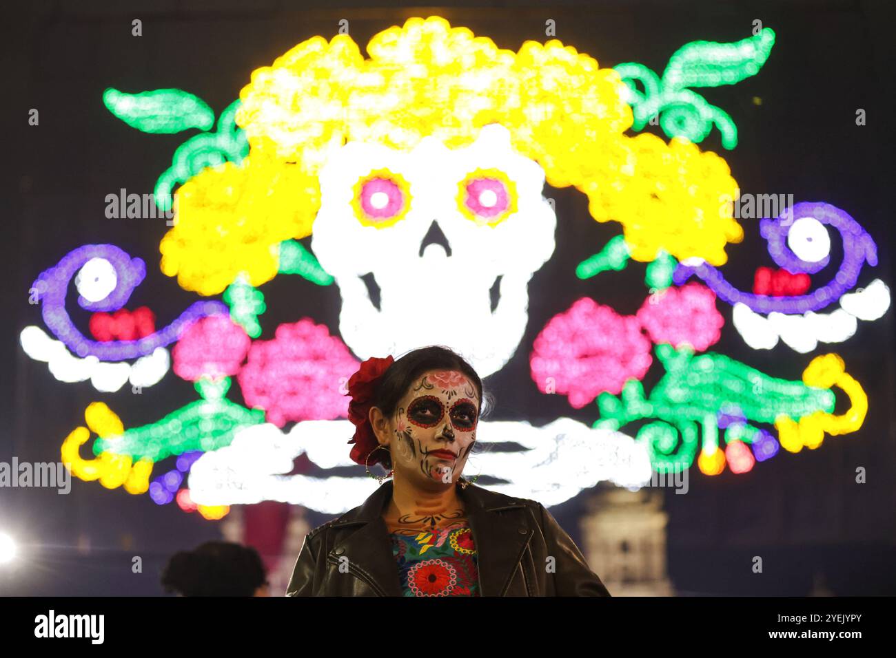 Mexico, Mexique. 30 octobre 2024. Une femme est photographiée avec pour toile de fond une installation lumineuse pour le jour des morts à Zocalo Square à Mexico, Mexique, Oct. 30, 2024. Crédit : Francisco Canedo/Xinhua/Alamy Live News Banque D'Images