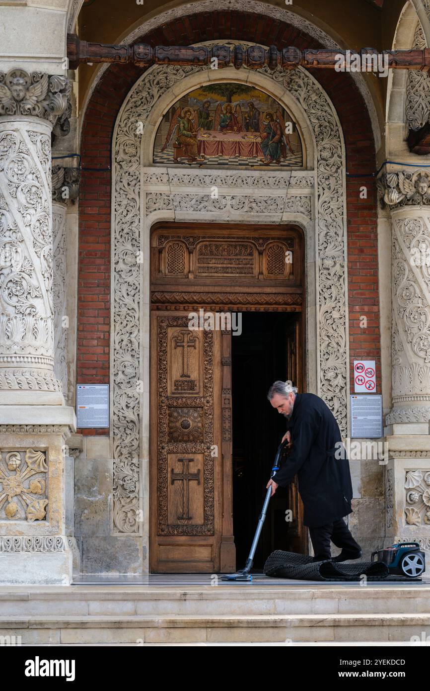 Vaccuuming l'entrée de la Biscerica Mare (Grande Église), Monastère de Sinaia, Transylvanie, Roumanie Banque D'Images