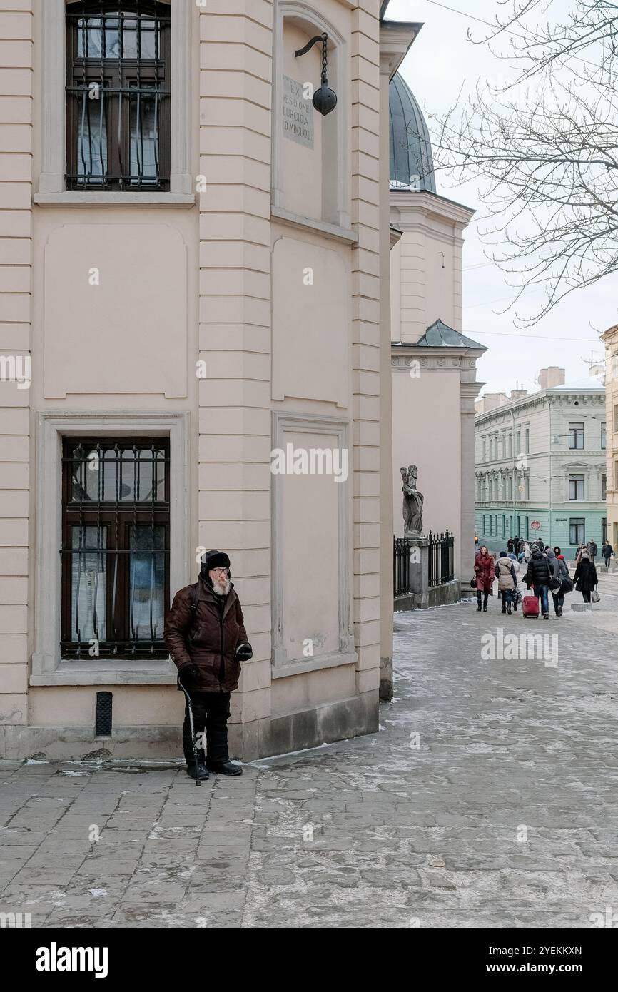 Lviv, Ukraine, 8 janvier 2015 : homme adulte âgé sans abri avec une longue barbe blanche et des vêtements pauvres demandant de l'argent aux gens debout sur la ville s Banque D'Images