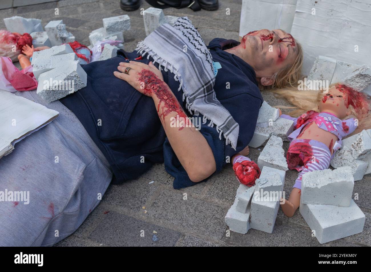 Southend on Sea, Royaume-Uni. 31 novembre 2024. Une femme gît dans Southend High Street avec un faux corps mutilé et une poupée en plastique représentant un bébé pour souligner l'horreur des événements de la vie quotidienne à Gaza. Penelope Barritt/Alamy Live News Banque D'Images