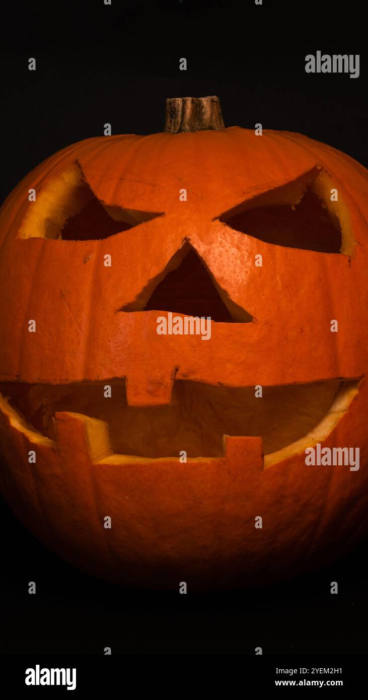 Papier peint ou bannière d'Halloween avec citrouille sculptée sur un fond noir Banque D'Images