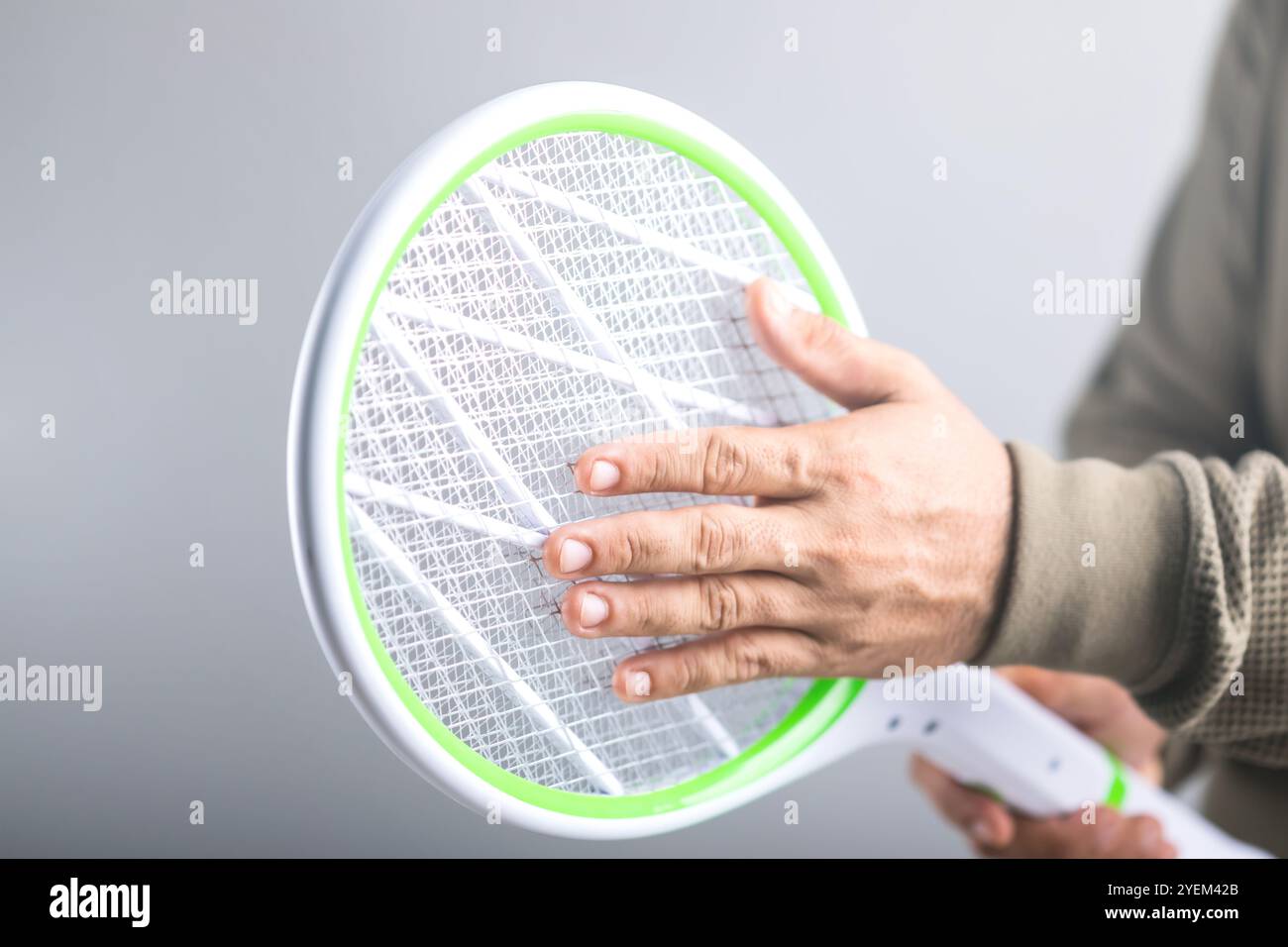 L'homme tient la tapette et touche son circuit, si elle constitue un danger physique pour le corps humain. Concept explore si une personne peut toucher Banque D'Images