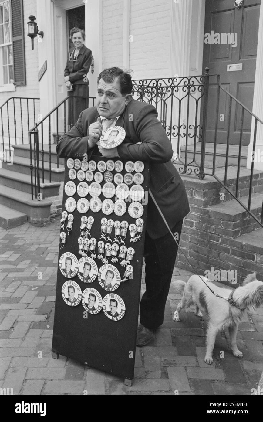 Homme froncé avec chien, vendant des boutons politiques soutenant l'élection de Richard M. Nixon, se tient devant le 3302 N Street, N.W., Georgetown, Washington D.C. en face de la maison du président élu John F. Kennedy. ÉTATS-UNIS. 6 décembre 1960 Banque D'Images