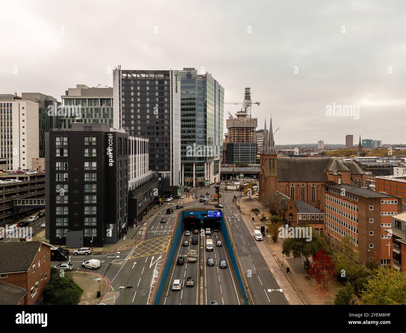 Vue aérienne du centre-ville de birmingham avec des voitures conduisant dans un tunnel, des bâtiments modernes et une église Banque D'Images