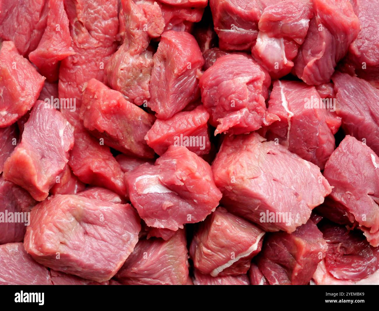 Boeuf en dés - gros plan de cubes de goulash de boeuf rouge. L'image détaillée est une invitation à cuisiner et est idéale pour les livres de cuisine ou les blogs alimentaires. Banque D'Images