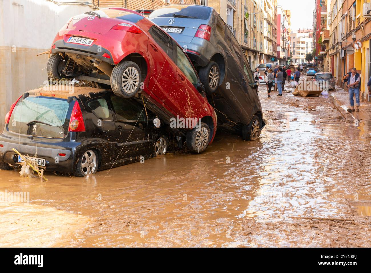 Catarroja, Valence, Espagne. 31 octobre 2024 - après la récente inondation, un voisin nettoie devant sa maison, alors qu'il y a encore des véhicules Banque D'Images