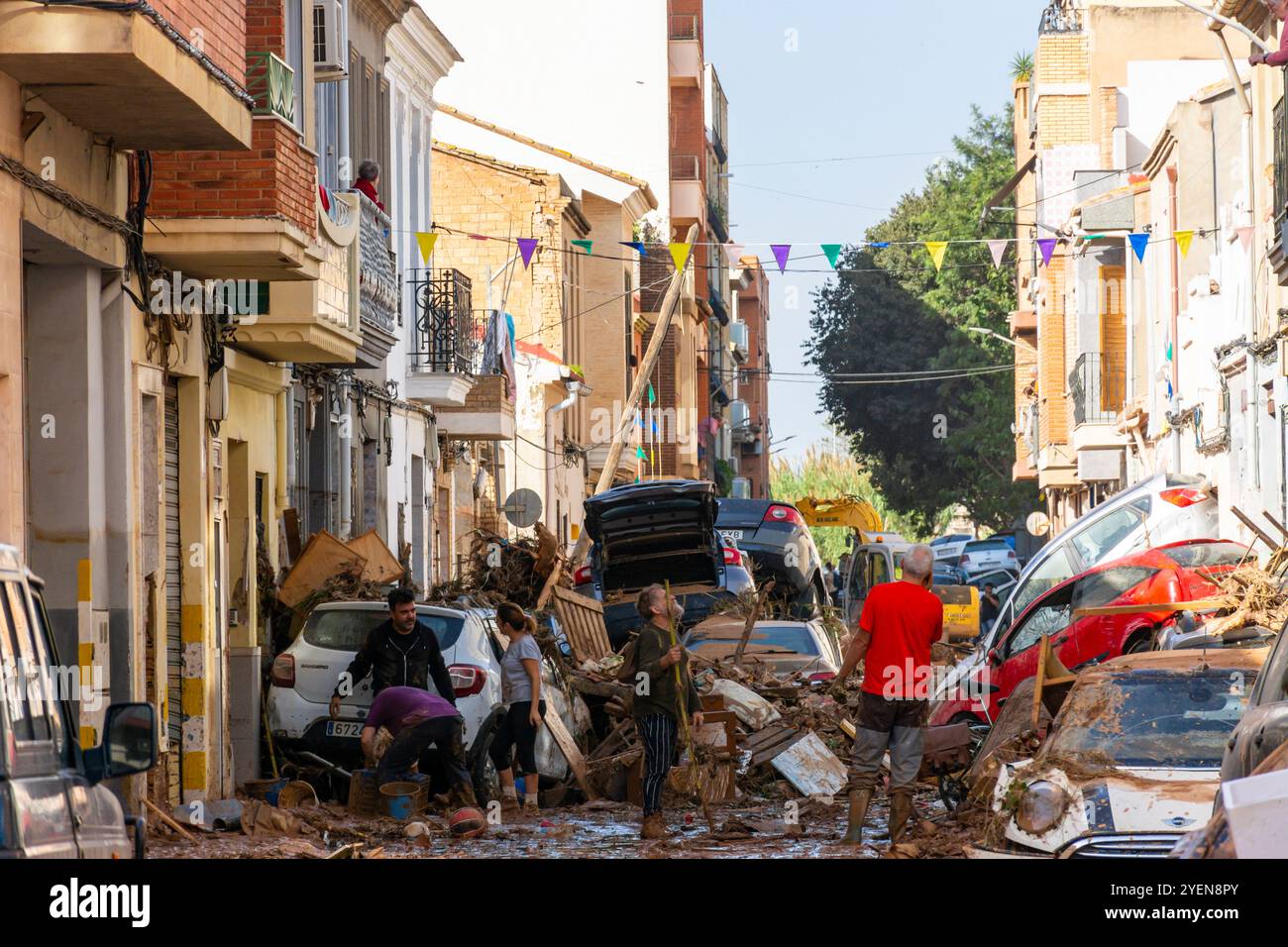 Massanassa, Valence, Espagne. 31 octobre 2024 - suite aux inondations dans la région, une rue de la ville semble pleine de véhicules empilés, tandis que les gens Banque D'Images