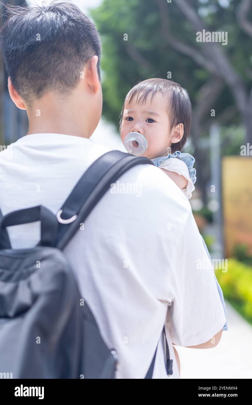 Une fille taïwanaise de 1 an sortant avec son père, un homme dans la vingtaine, par une chaude journée ensoleillée dans les rues de Taichung City, Taiwan, en septembre. Banque D'Images