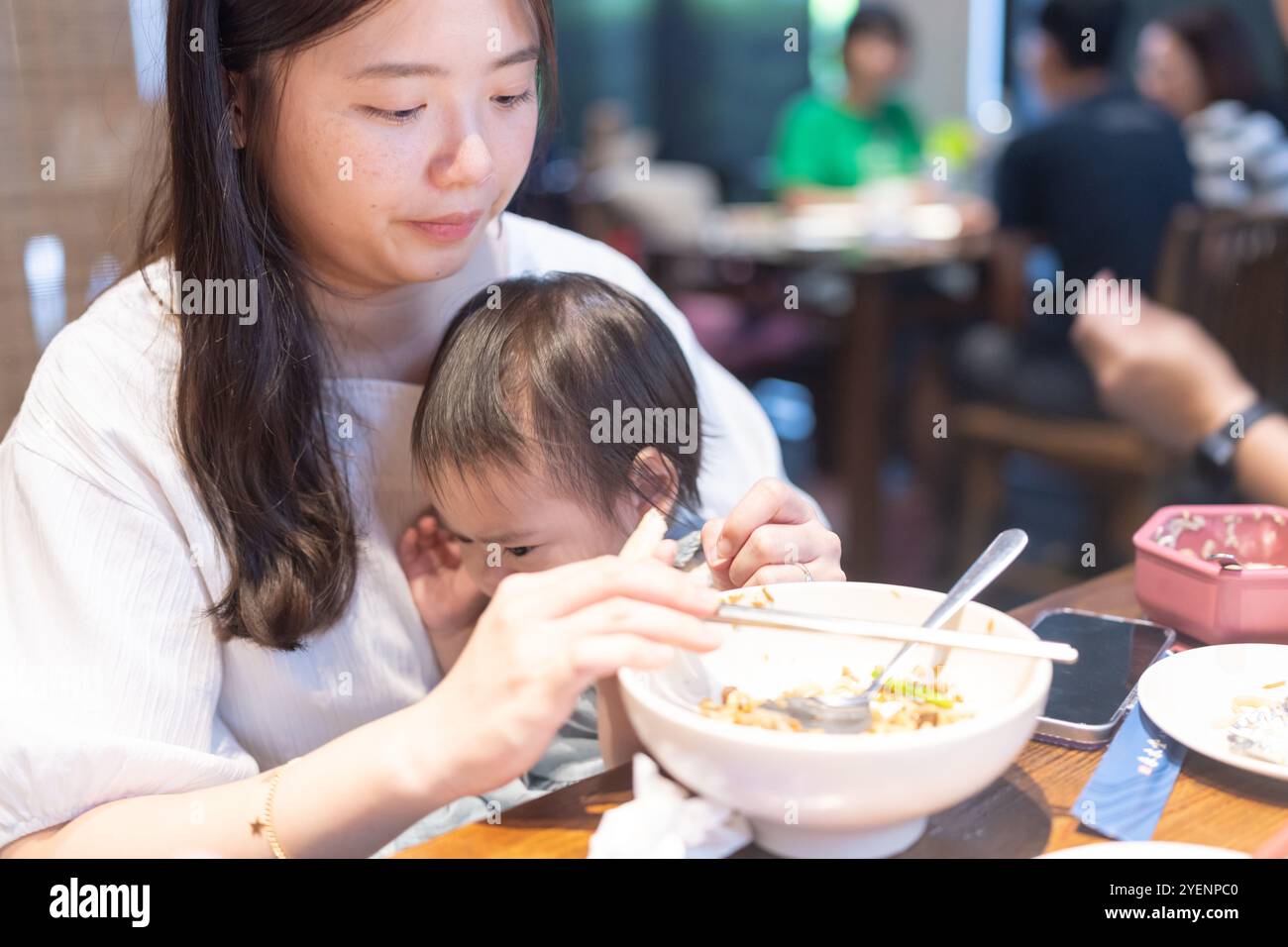 Une fille taïwanaise de 1 an prenant un repas avec ses parents, un homme et une femme dans la vingtaine, dans un célèbre restaurant chinois à Taichung City, Taiwan. Banque D'Images