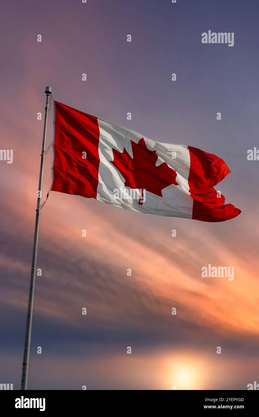 Drapeau du Canada soufflant dans le vent au coucher du soleil Banque D'Images