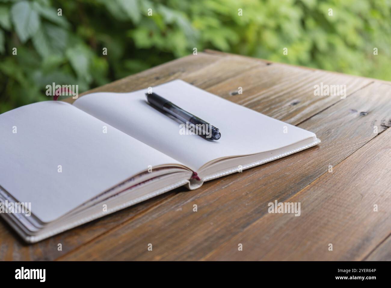 Ouvrez le bloc-notes en papier blanc vide sur la table en bois à l'extérieur. Concept d'auteur écrivant dans une atmosphère confortable détendue. La détox numérique de santé spirituelle ralentit Banque D'Images