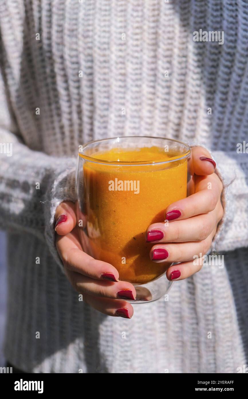 Femme méconnaissable portant un smoothie pimpkin épicé latte. Café d'automne avec boisson chaude de saison au goût de citrouille épicée. Boissons d'automne pour Halloween et Banque D'Images