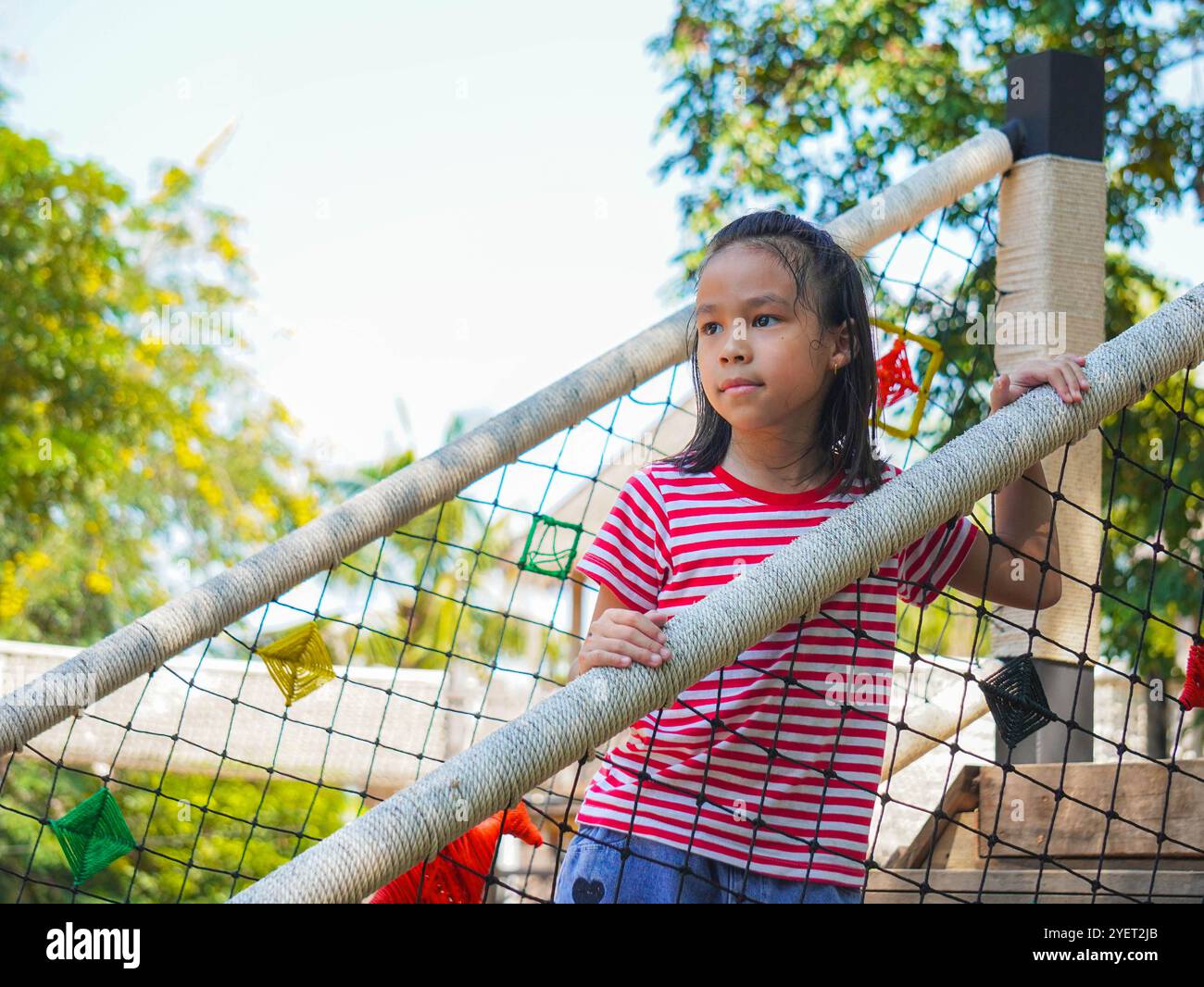 Les enfants jouent à l'extérieur sur une aire de jeux avec toboggans modernes, ponts en filet de corde, balançoires d'escalade, grimpeurs en été. Banque D'Images