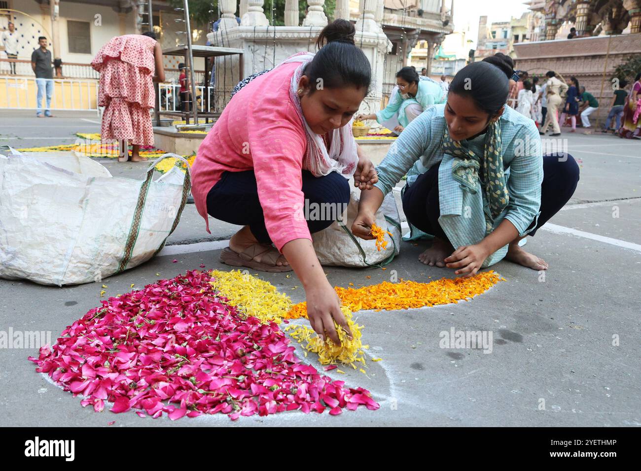 Femmes créant des motifs rangoli à partir des pétales de fleurs, pour célébrer le festival de Diwali, à Ahmedabad, Gujarat, Inde Banque D'Images