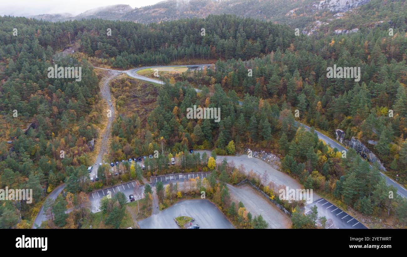 Vue aérienne d'une zone boisée avec des routes sinueuses et des parkings, entourée d'arbres denses et de collines. Banque D'Images