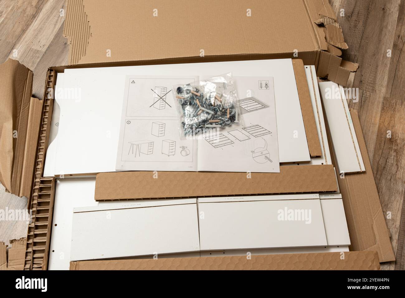 Une boîte de vis et un sac de vis se trouvent sur la boîte avec les meubles et les instructions de montage. Assemblage de meubles. Banque D'Images