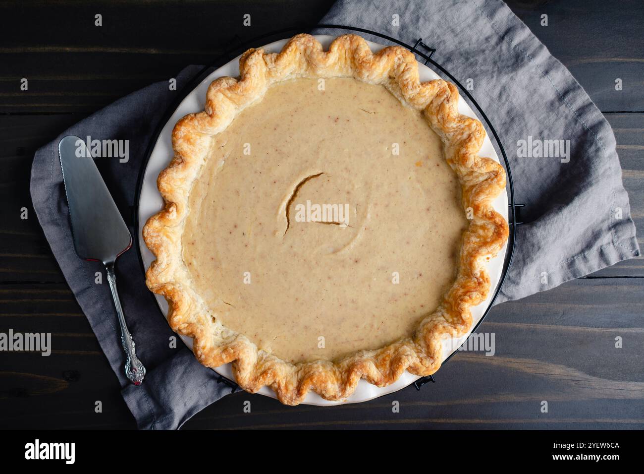 Tarte à la citrouille blanche maison avec serveur à tarte : vue de dessus d'une tarte à la citrouille blanche avec une croûte cannelée dans un plat à tarte en céramique Banque D'Images