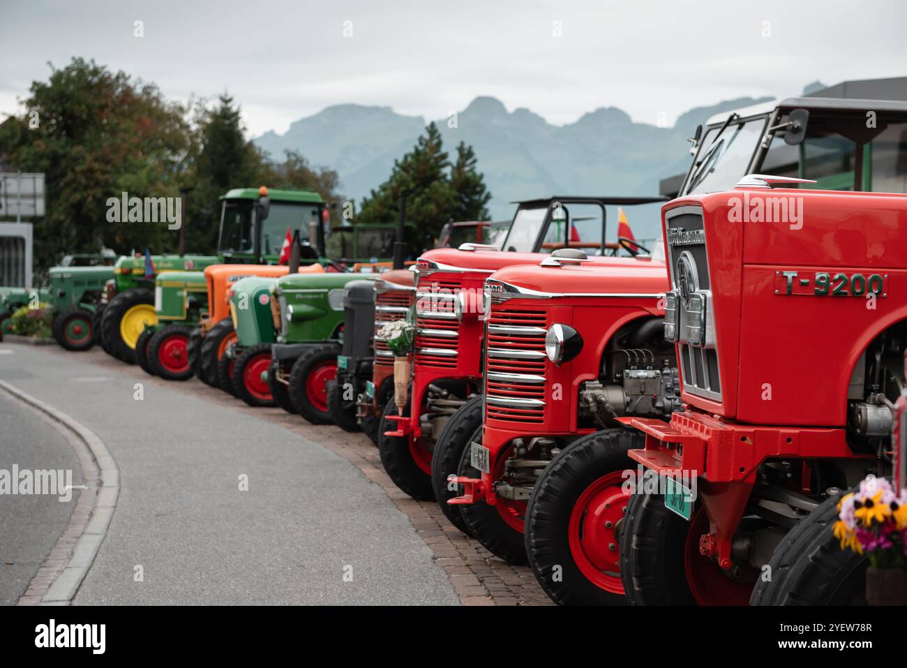 Vieux tracteurs garés en rangée. Tracteurs vintage placés le long de la route après le festival de rassemblement des agriculteurs. Banque D'Images