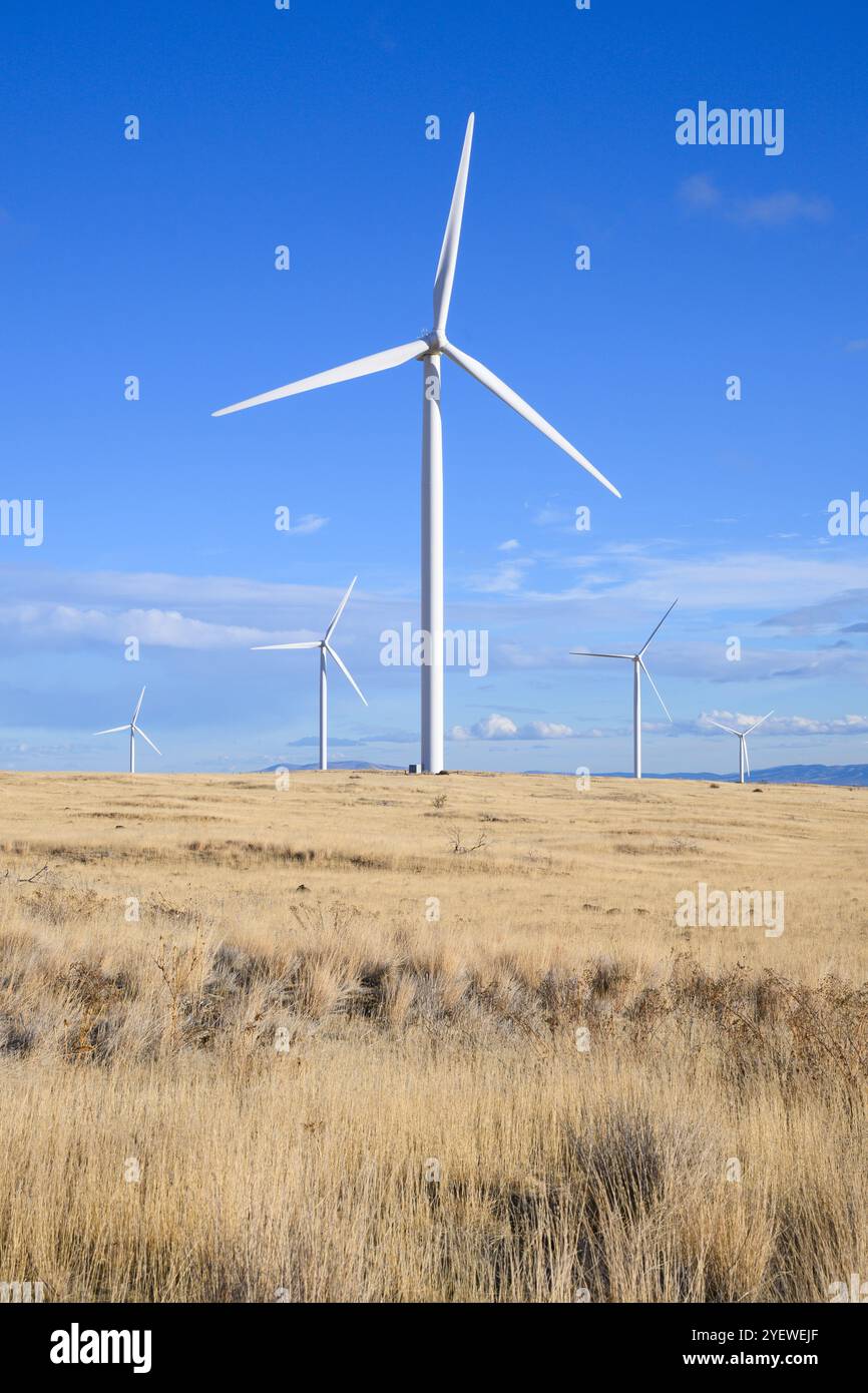 Éolienne debout haut au-dessus du paysage aride sec contre le ciel bleu Banque D'Images