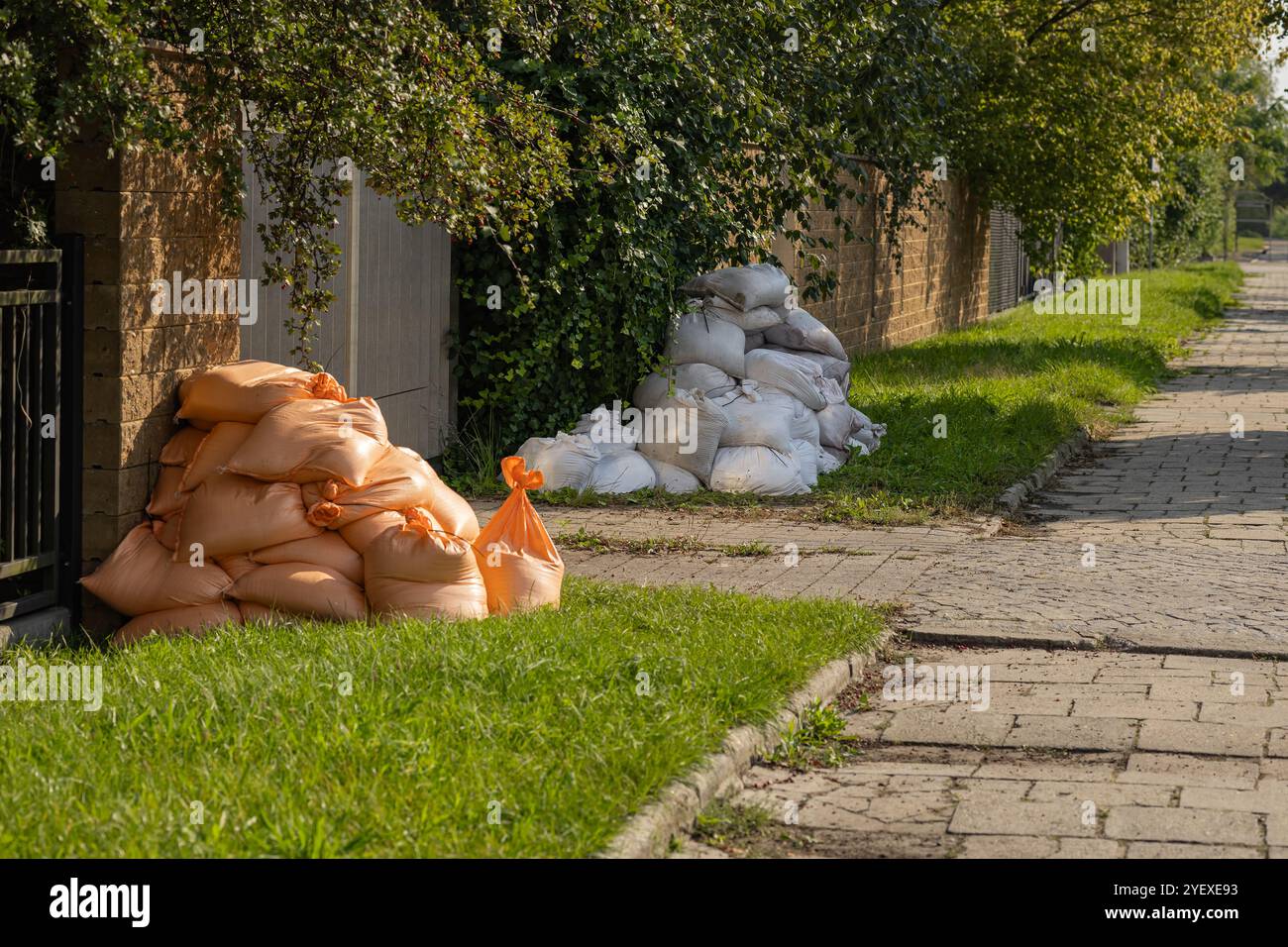 Protection résidentielle contre les inondations avec des sacs de sable tapissant un trottoir pour éviter les dégâts d'eau pendant la saison des inondations. Préparation aux situations d'urgence et protection à domicile Banque D'Images