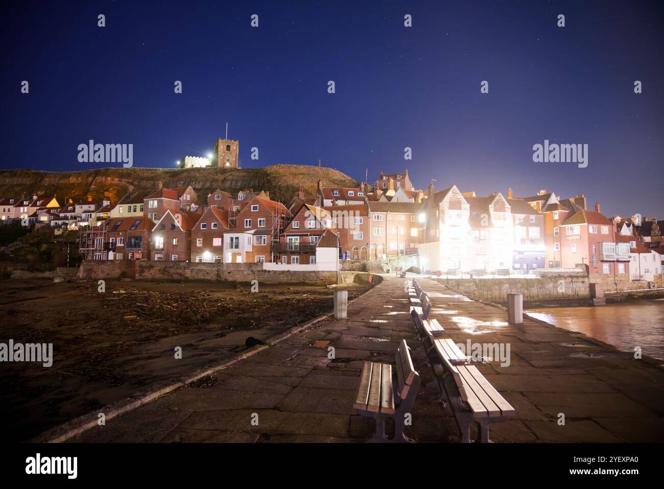 Église St Hilda illuminée au-dessus de la vieille ville de Whitby, Angleterre. Banque D'Images