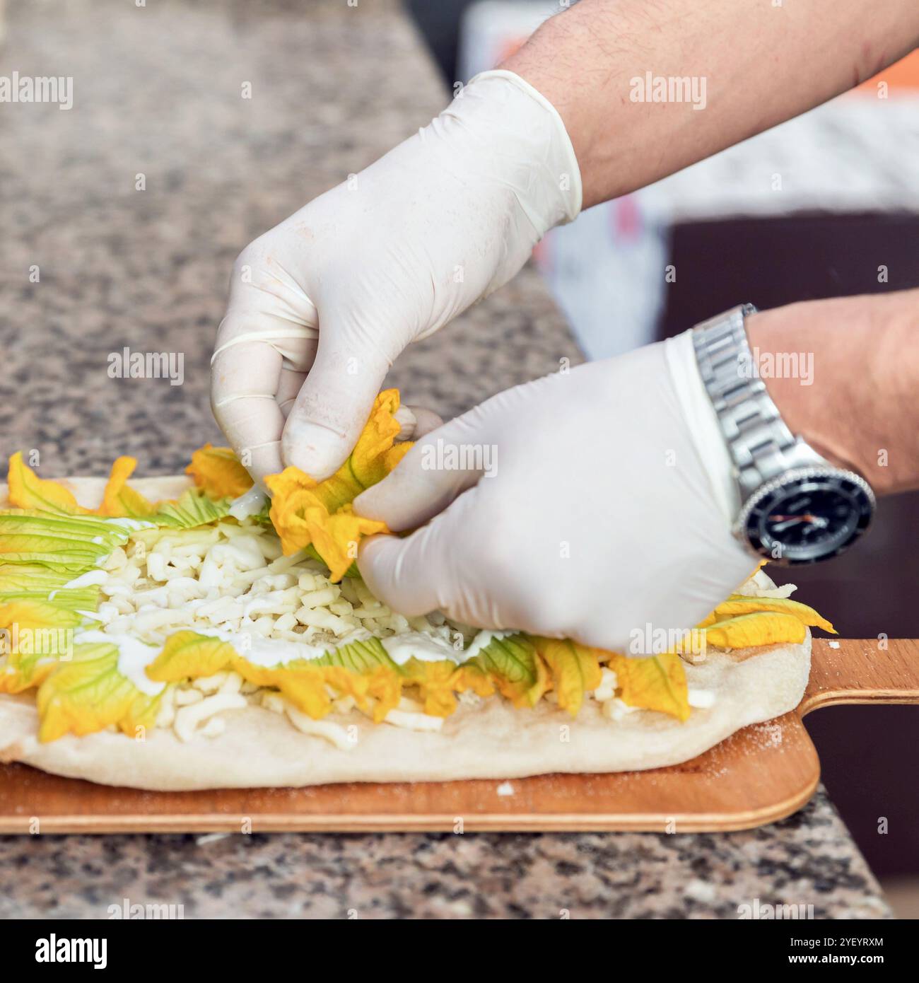 Mains de chef avec des gants blancs faisant pizza. Pizza Art. Le processus de fabrication de pizza. Banque D'Images